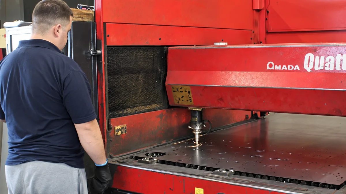 An operator working at Traker's laser cutting machine